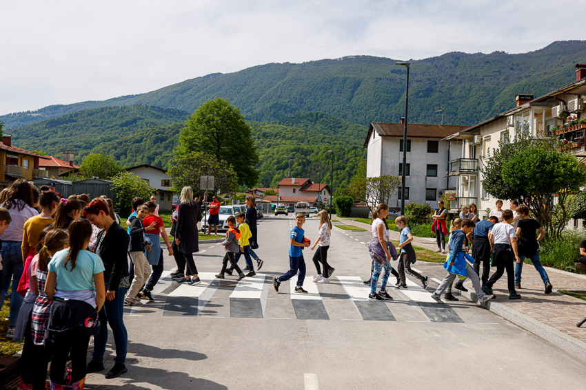 Osnovnošolski otroci s prečkanjem preizušajo novo 3D-zebro, ki jo je v njihovo šolsko okolje umestil Generali.