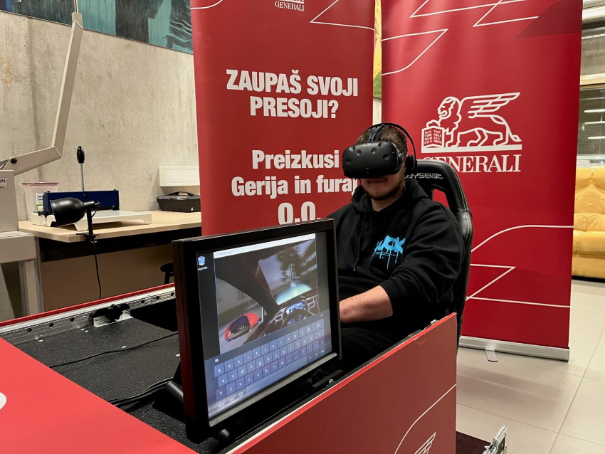 Udeleženec delavnice Heroji furajo v pižamah v Velenju preizkuša simulator vožnje Geri zavarovalnice Generali.