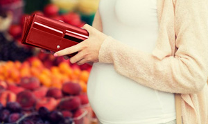 Nosečnica gleda v odprto denarnico