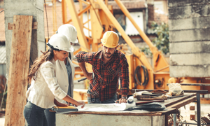 Ekipa gradbincev pri delu pregleduje načrte