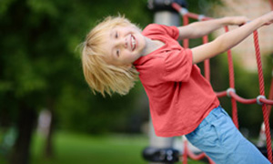 Otrok se razigrano obeša po igralih