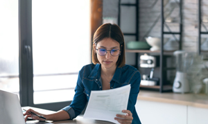 LAstnica malega podjetja skrbno pregleduje stroške ob koncu delovnega dne