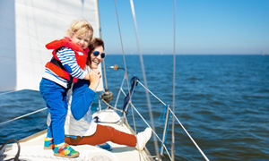 Fotografija mamice in otroka na čolnu na morju