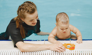 Dojenček v bazenu na plavalnem tečaju