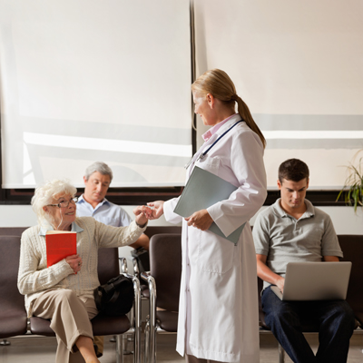 Pacienti čakajo v čakalnici - simbolna slika za čakalne dobe v zdravstvenem sistemu.