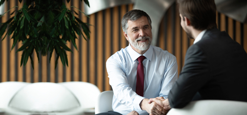 Dva poslovneža v pogovoru - kolektivna zdravstvena zavarovanja lahko dvignejo zadovoljstvo zaposlenih