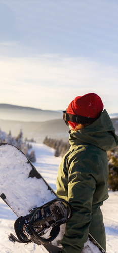 Deskar na smučišču občuduje sončni zahod - simbolna slika za zavarovanje za smučanje