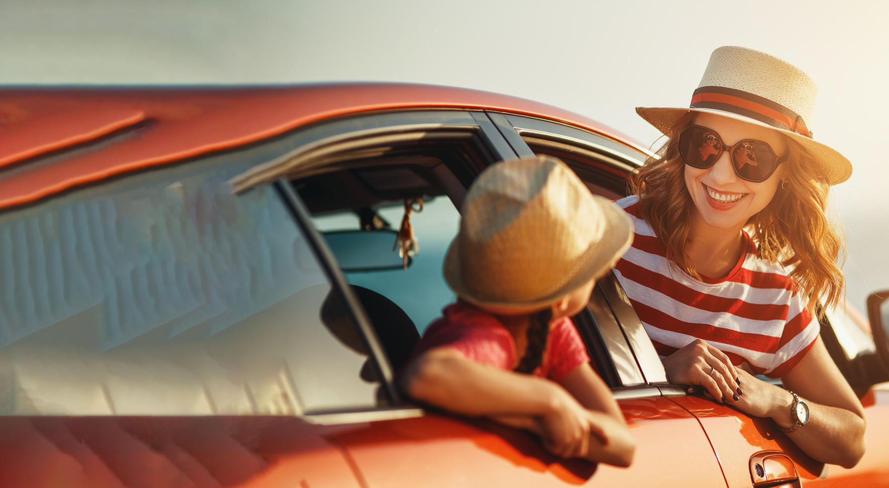 Mama gleda skozi okno avtomobila v sončnem zahodu in se namiha svojemu otroku - malčku.