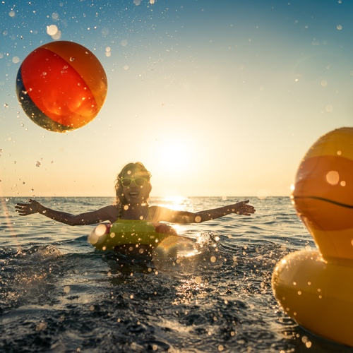 Mlada ženska uživa poletne počitnice med čofotanjem v morju