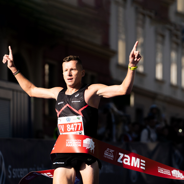 Zmagovalec polmaratona Generali ZAME zmagoslavno zaključuje tek v ciljni areni.