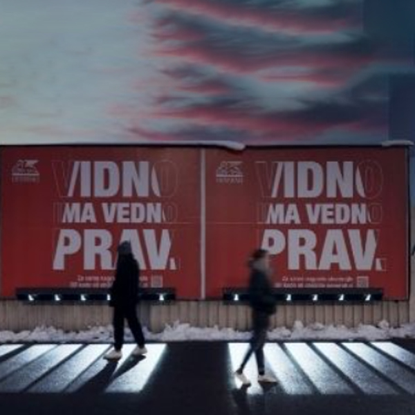 Obcestni plakat ponoči - z razsvetljavo, ki osvetjuje pločnik tako, da se nanj izriše zebra - prehod za pešce