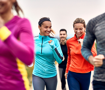 Skupina tekačev v parku na treningu, s katerim krepijo telo in odpornost.