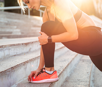 Tekačica se je med tekom ustavila in se prijema za nogo, kjer čuti bolečino.