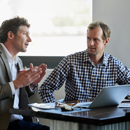 Poslovnež med pogovorom z zastopnikom o tveganjih za njegovo podjetje