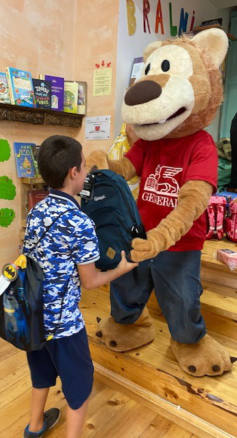 Levček, ki otroku iz programa predaja šolsko torbo