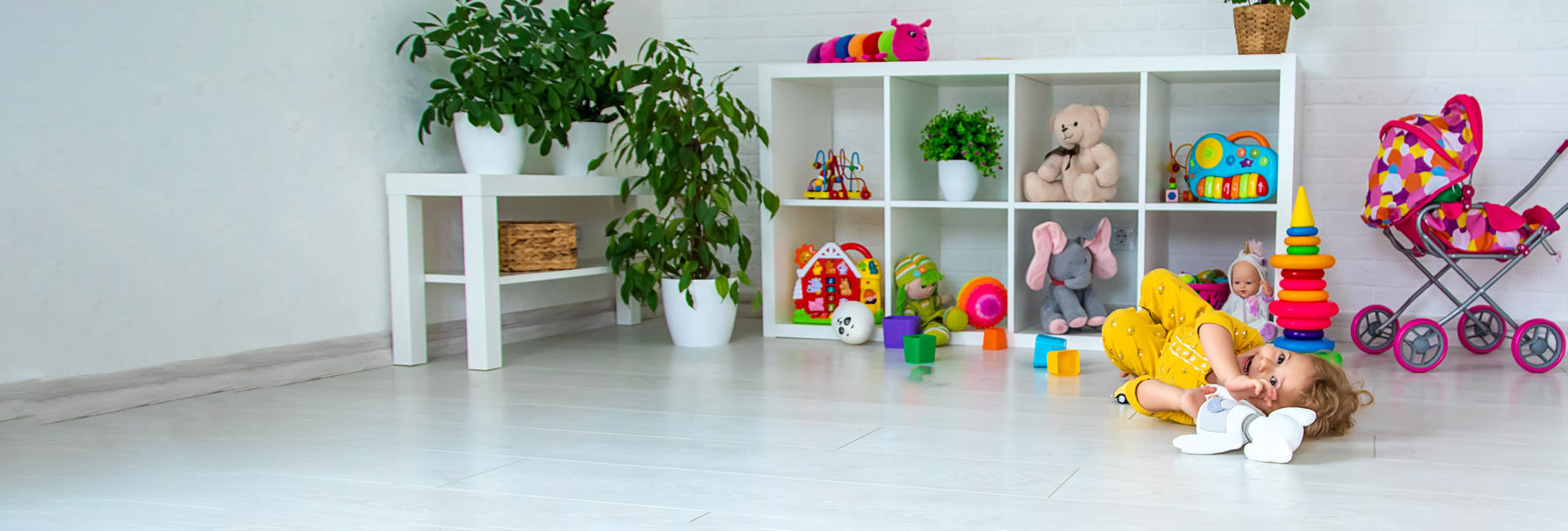 Mlačica se na tleh igra s plišasto igračko