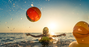 Ženska se ob sončnem zahodu zabava v morju.