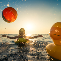 Mlada ženska uživa poletne počitnice med čofotanjem v morju