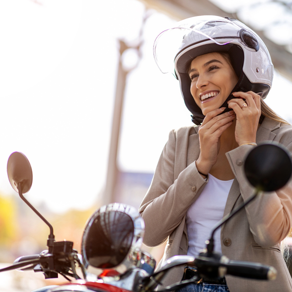 Ženska na motorju s čelado na glavi