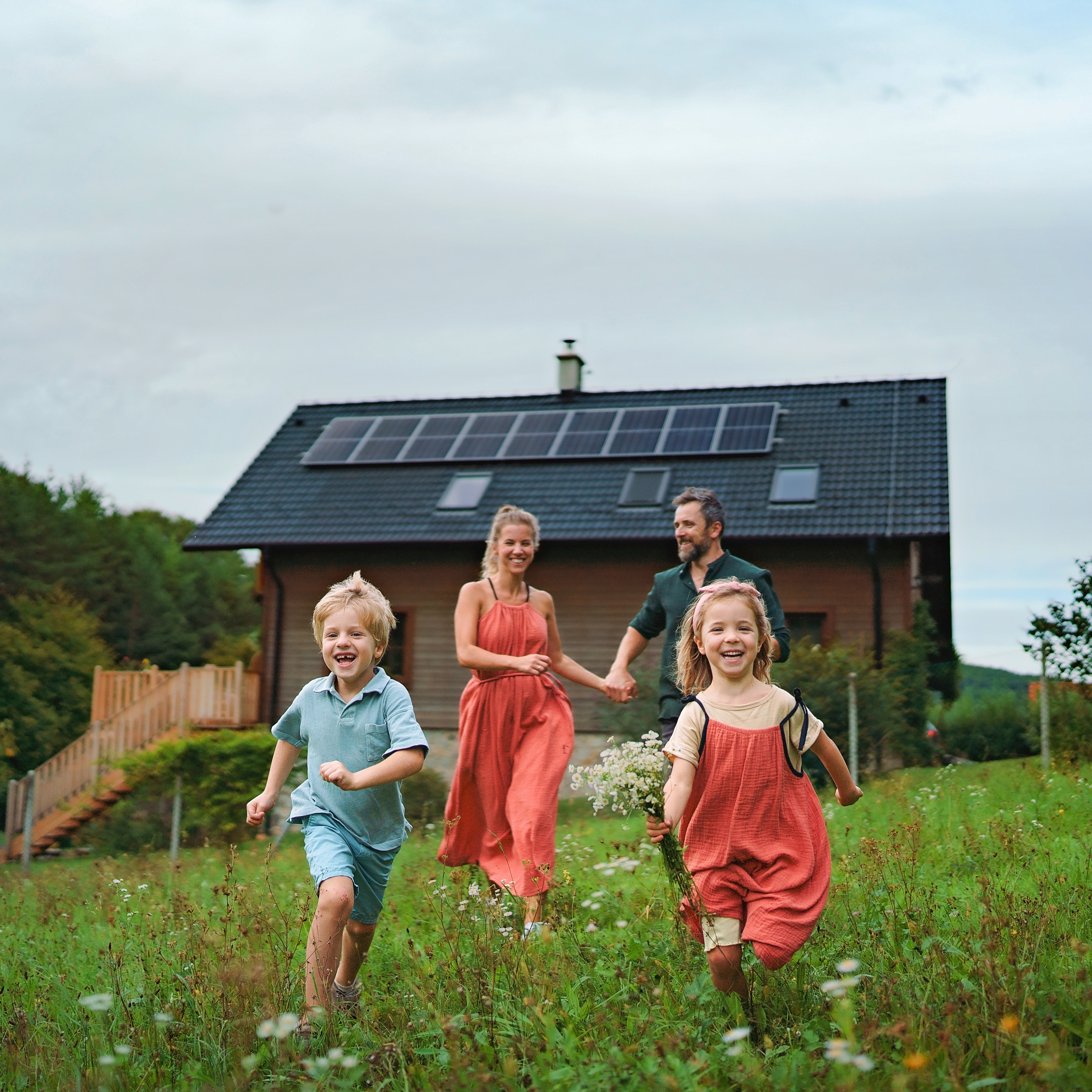 Družina pred hišo s sončno elektrarno