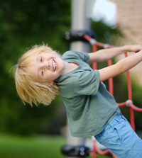Otrok se razposajeno igra na igralih - simbolna slika za nezgodno zavarovanje
